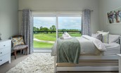 Bellshill Bothy - bedroom two balconette with large sliding doors offering far-reaching views towards the coast
